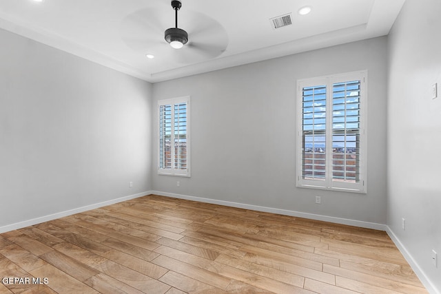 empty room featuring light hardwood / wood-style floors, a wealth of natural light, and ceiling fan