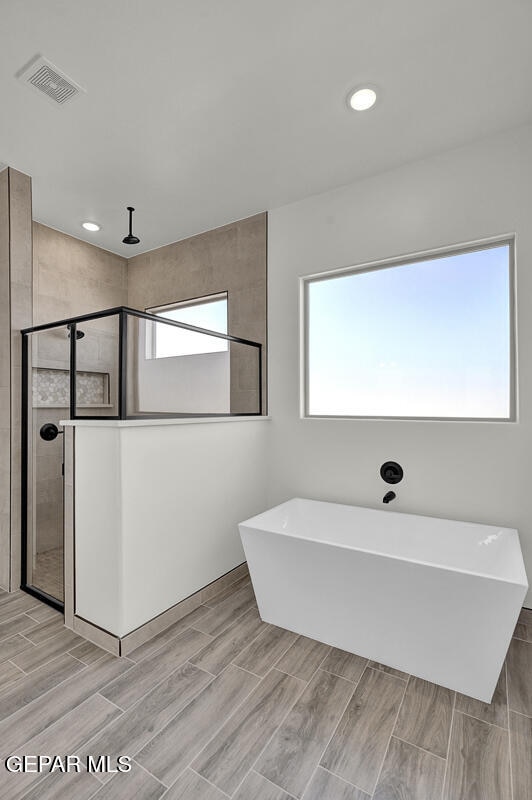 bathroom featuring separate shower and tub and hardwood / wood-style floors