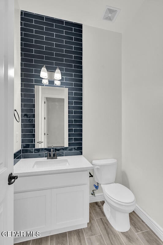 bathroom with vanity, toilet, and wood-type flooring