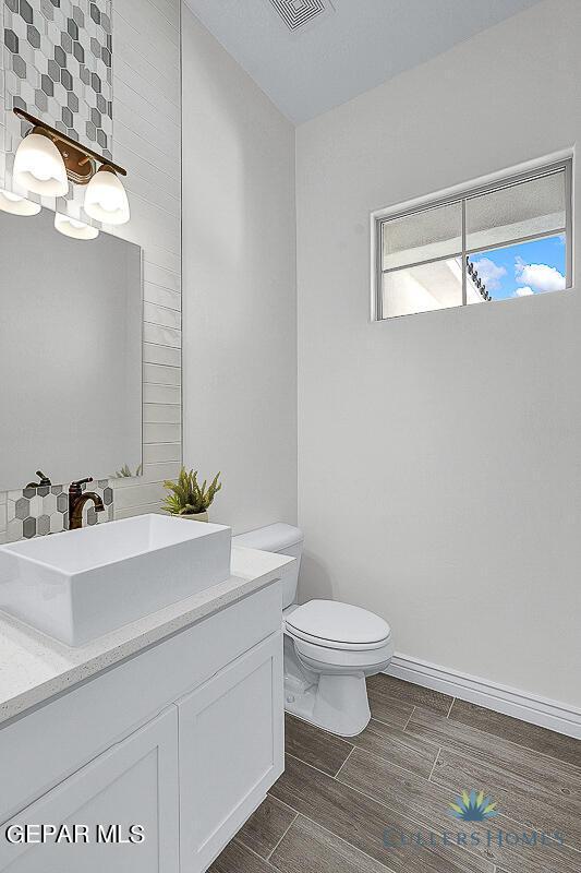 bathroom with tile patterned floors, toilet, decorative backsplash, and vanity