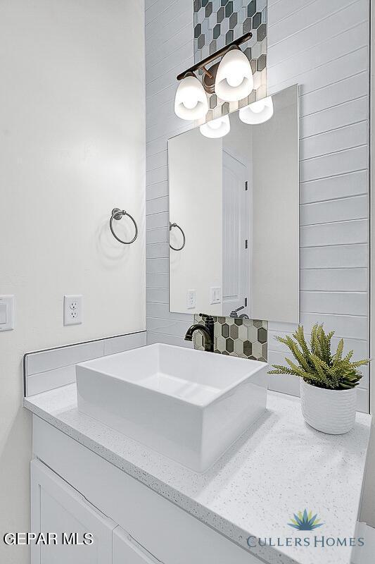 bathroom with decorative backsplash and vanity