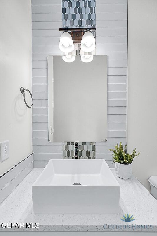 bathroom featuring backsplash and toilet