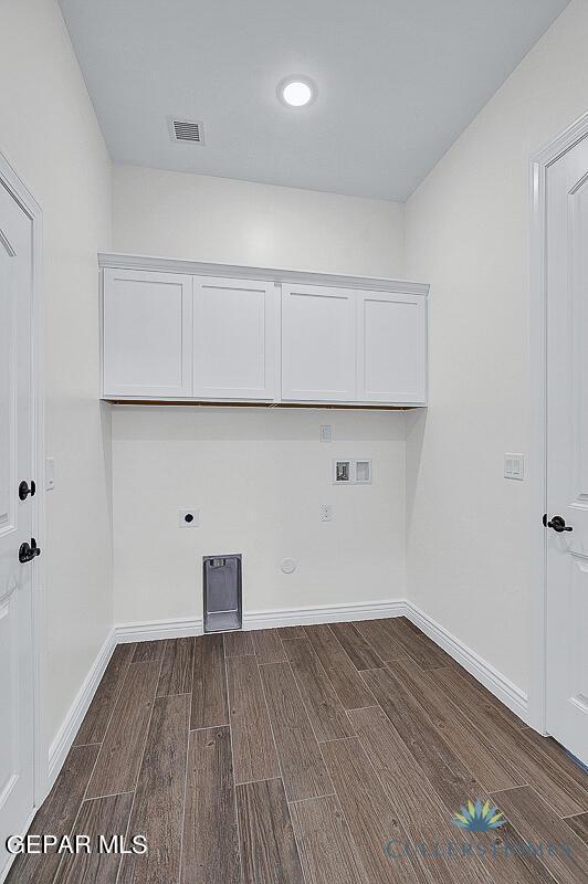 washroom with electric dryer hookup, hookup for a washing machine, cabinets, and hardwood / wood-style floors