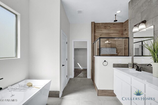 bathroom with independent shower and bath, vanity, and tile patterned floors