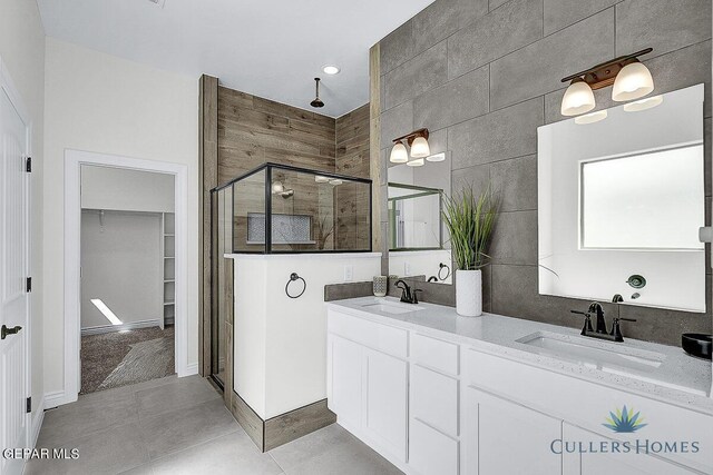 bathroom featuring an enclosed shower, double vanity, tile patterned floors, and tile walls