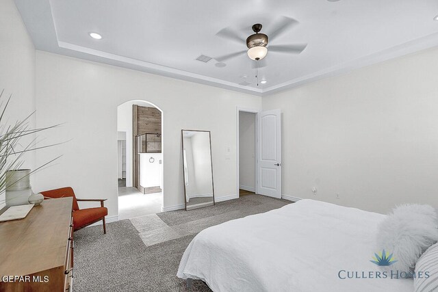 bedroom with a tray ceiling, ceiling fan, and light carpet