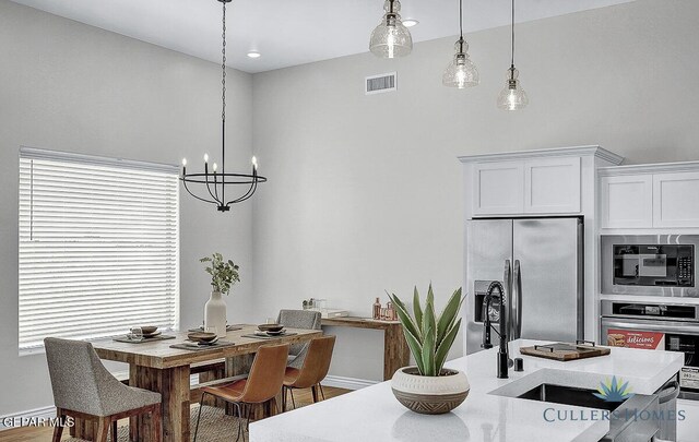 dining room with hardwood / wood-style flooring, a healthy amount of sunlight, and a chandelier