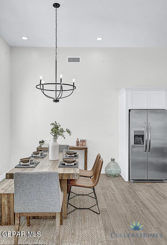 dining space featuring light hardwood / wood-style floors and a chandelier