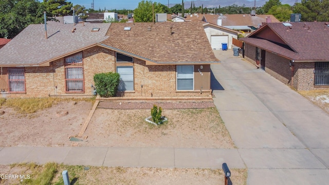 view of front of home featuring brick siding and roof with shingles