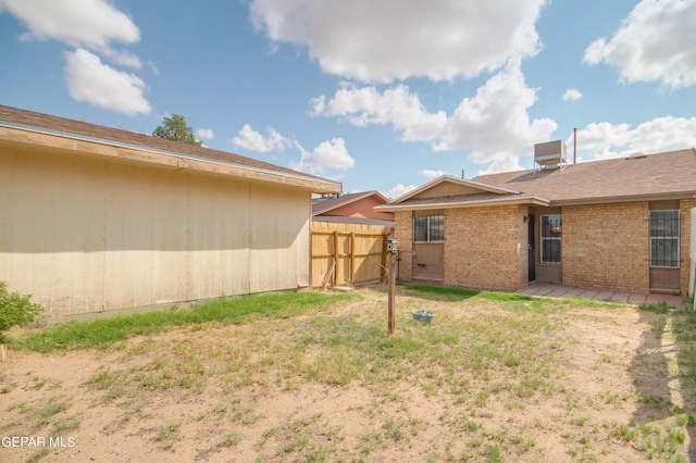 view of yard with central AC unit and fence