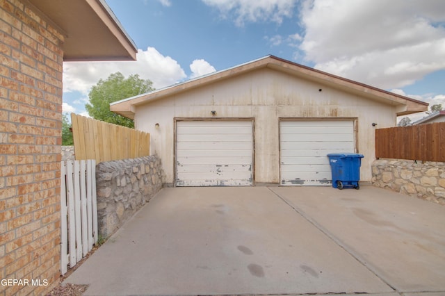 detached garage featuring fence