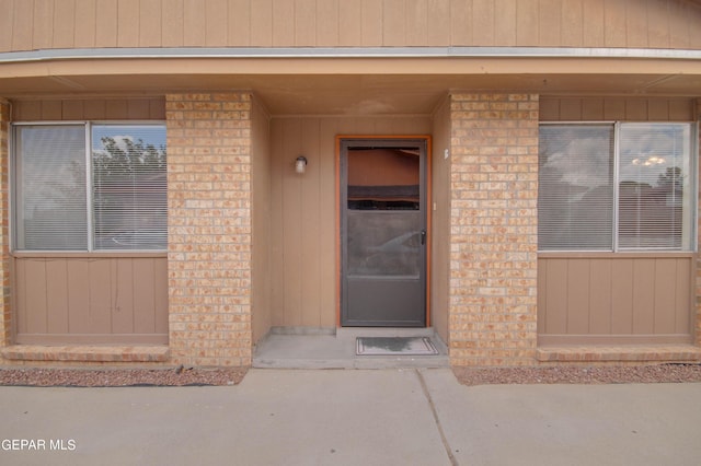 doorway to property featuring brick siding