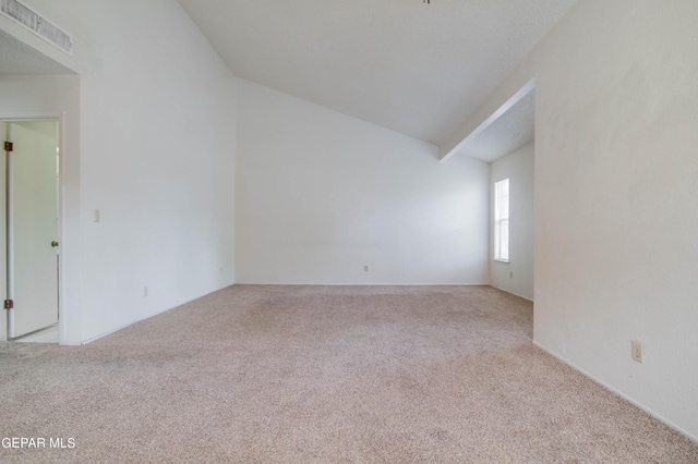 carpeted empty room with lofted ceiling and visible vents