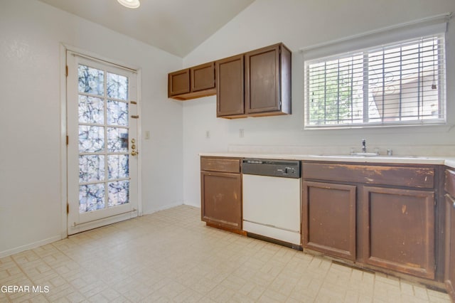 kitchen with light floors, dishwasher, light countertops, lofted ceiling, and a sink