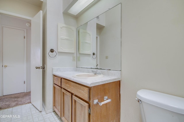 half bathroom featuring vanity, tile patterned floors, and toilet