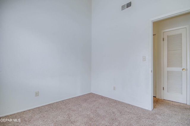 empty room featuring visible vents and carpet flooring