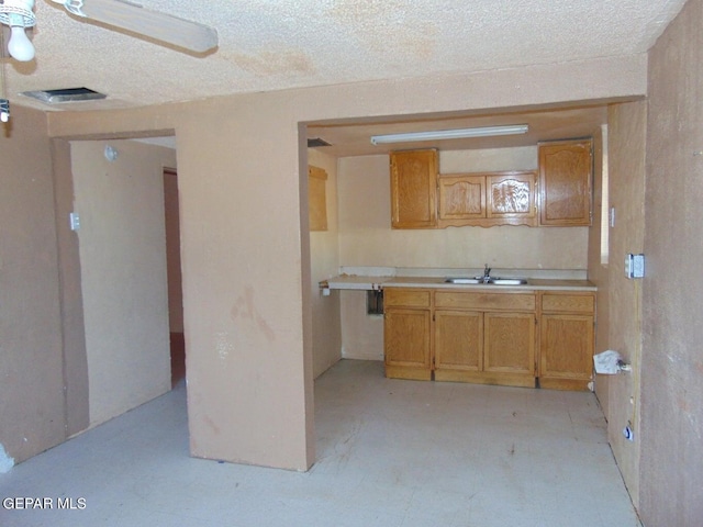 kitchen with sink, ceiling fan, and a textured ceiling