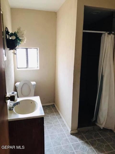 bathroom with toilet, vanity, and tile patterned floors