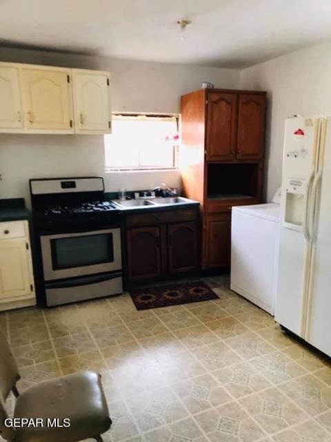 kitchen featuring white cabinets, sink, white fridge with ice dispenser, stove, and light tile patterned flooring