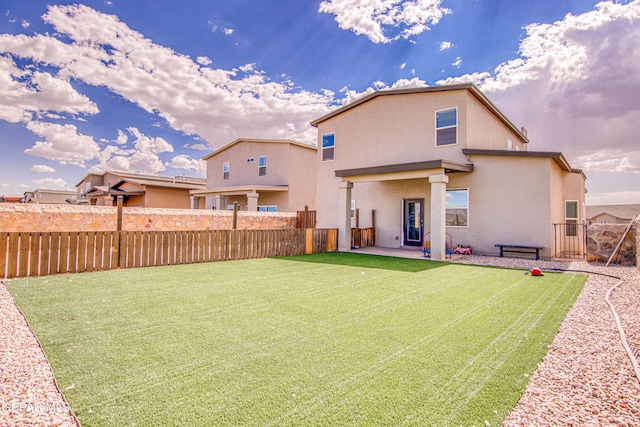 rear view of house with a patio area and a yard