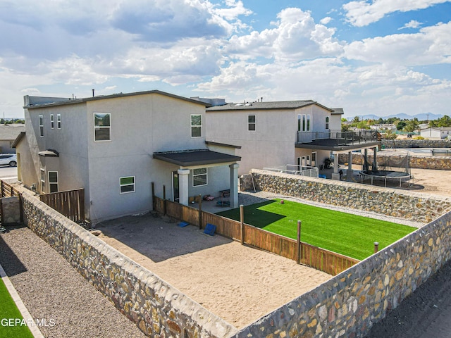 back of property with a patio area, a yard, and a balcony