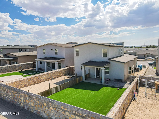 back of house with a patio area and a lawn