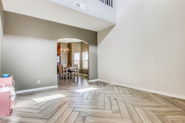 spare room featuring a chandelier and light parquet floors