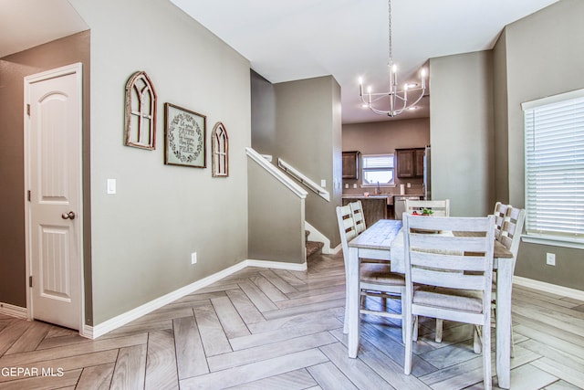 dining area featuring sink, a notable chandelier, and light parquet floors