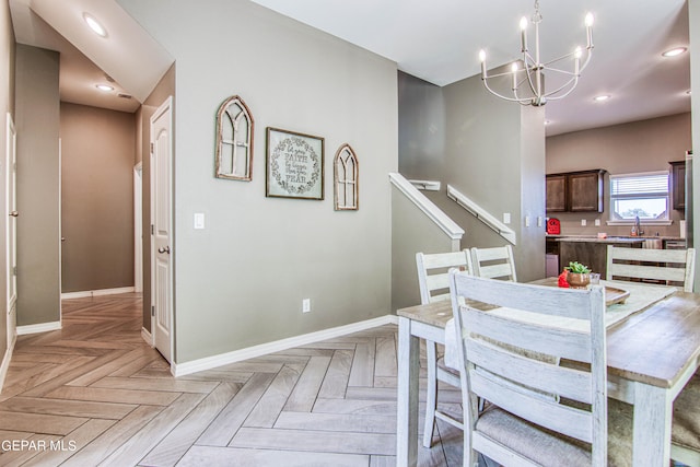 dining area featuring sink, a notable chandelier, and light parquet floors