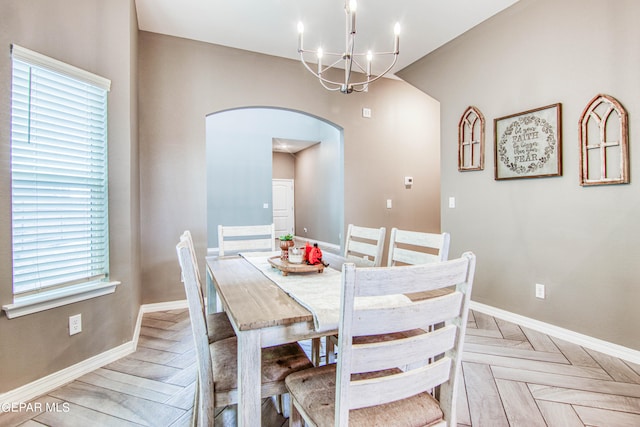 dining area featuring light parquet flooring and a chandelier