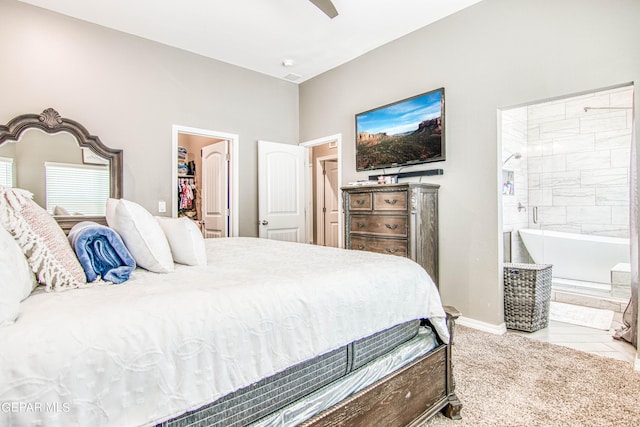 bedroom featuring ceiling fan, light tile patterned flooring, and a walk in closet