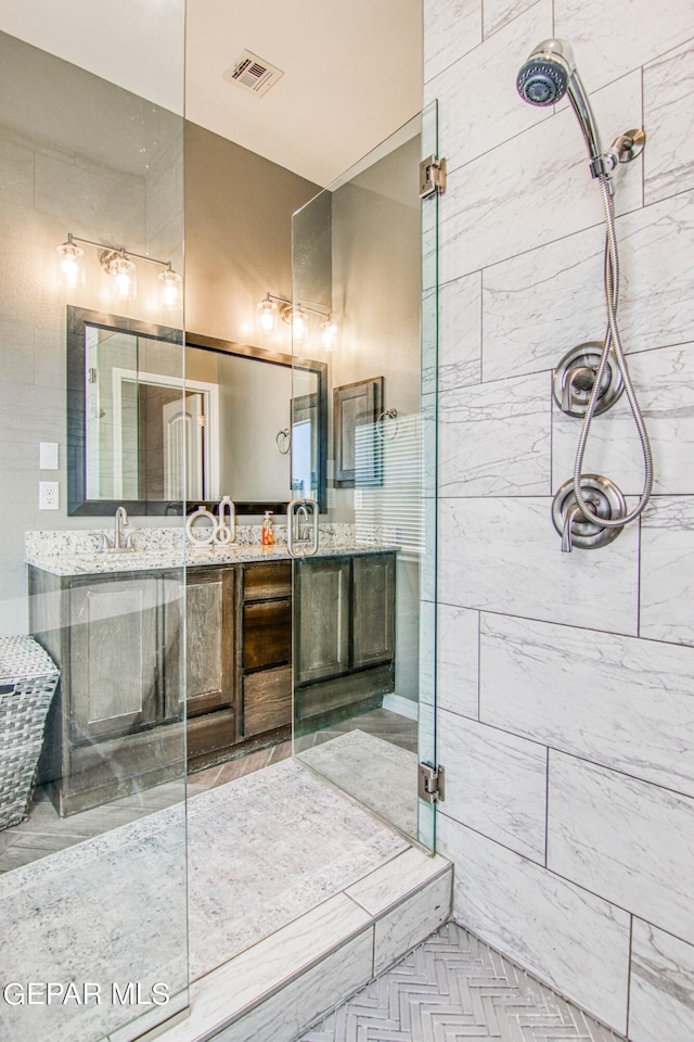 bathroom featuring a tile shower and vanity