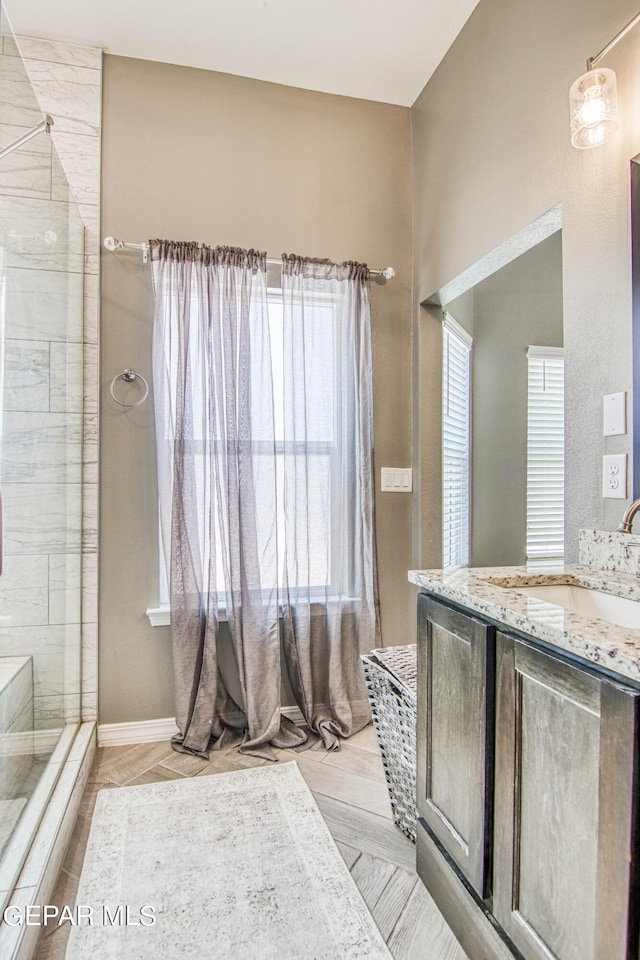 bathroom with vanity and tiled shower