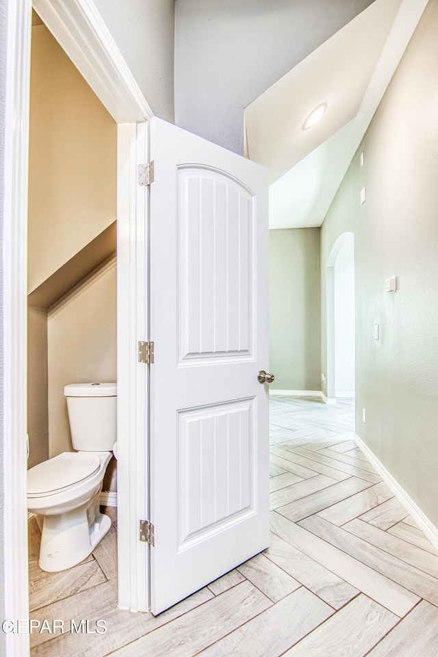 bathroom with parquet floors and toilet