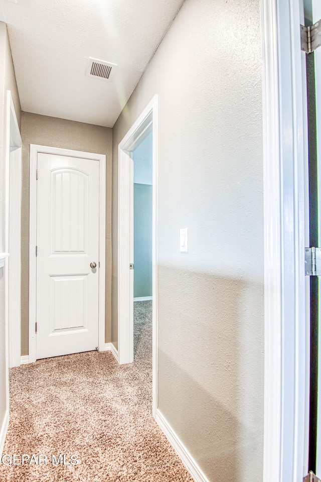 hallway with light colored carpet