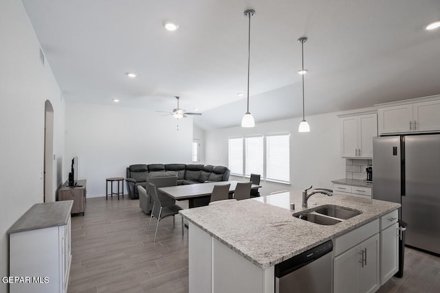 kitchen featuring decorative backsplash, an island with sink, sink, lofted ceiling, and stainless steel appliances