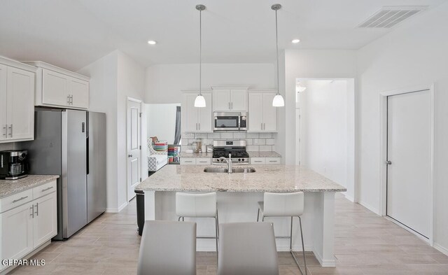 kitchen featuring white cabinetry, stainless steel appliances, and decorative backsplash