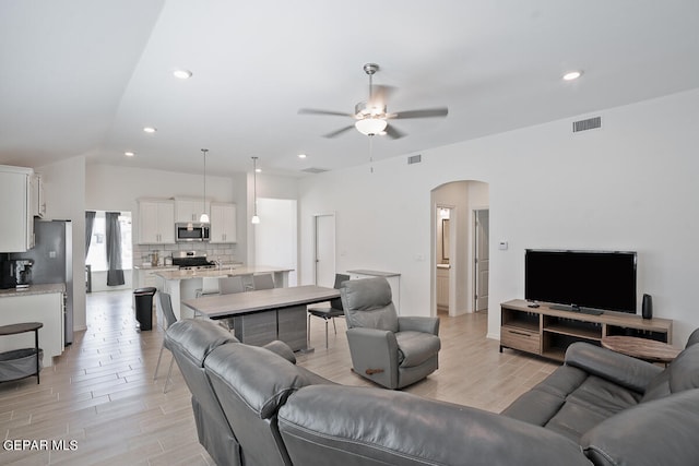 living room with ceiling fan and light hardwood / wood-style floors