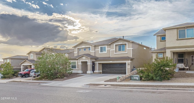 view of front of house with driveway, an attached garage, a residential view, and stucco siding