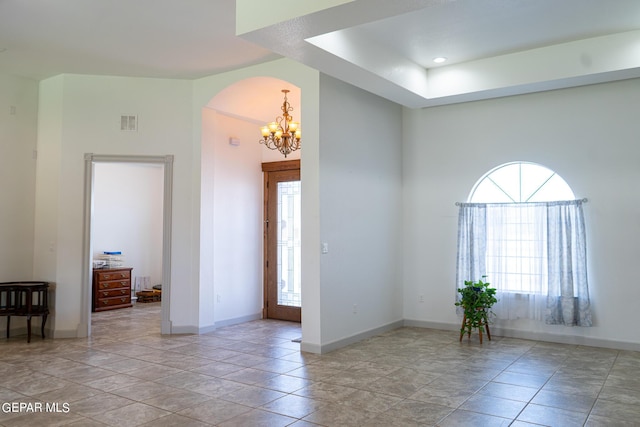 spare room featuring visible vents, a notable chandelier, and baseboards