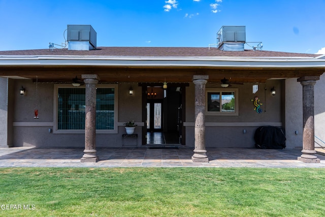 exterior space featuring a yard, roof with shingles, and stucco siding