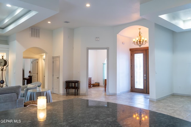 entrance foyer with arched walkways, recessed lighting, a raised ceiling, visible vents, and baseboards