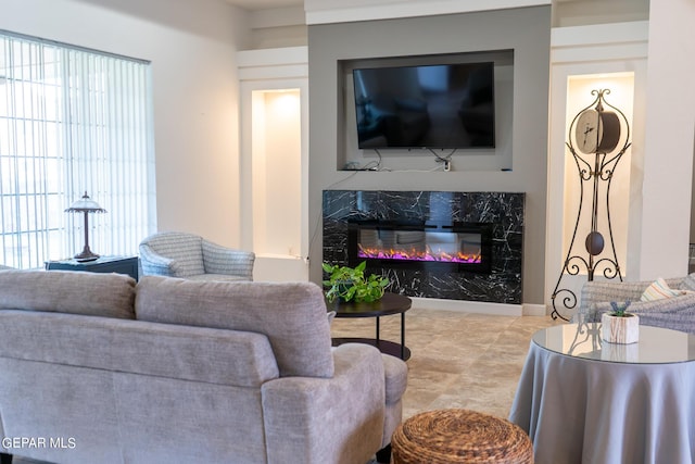 living area featuring a high end fireplace and a healthy amount of sunlight