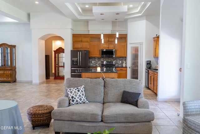 kitchen featuring stove, black fridge with ice dispenser, open floor plan, stainless steel microwave, and dark countertops