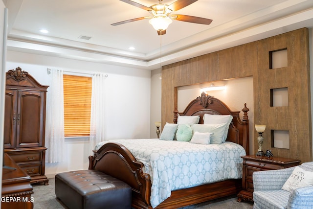 carpeted bedroom featuring ceiling fan, a raised ceiling, visible vents, and recessed lighting