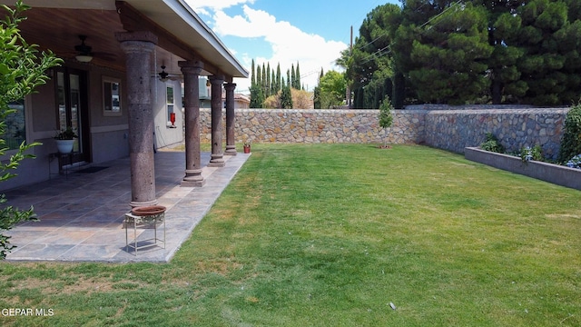 view of yard with ceiling fan and a patio