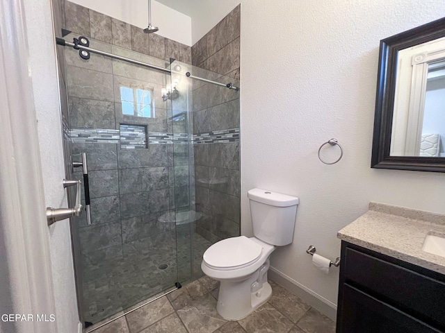 bathroom featuring toilet, a shower stall, baseboards, and vanity