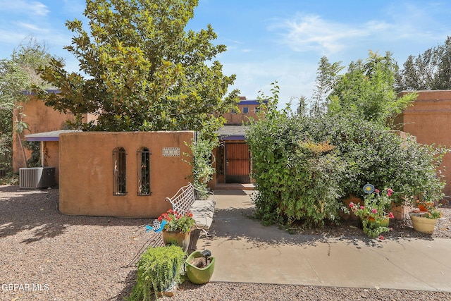 southwest-style home with central AC, fence, a gate, and stucco siding