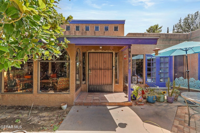 view of exterior entry featuring stucco siding