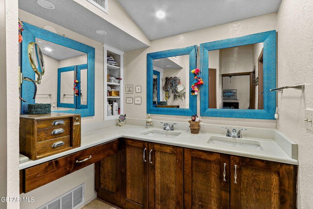 bathroom featuring vanity, built in features, and vaulted ceiling